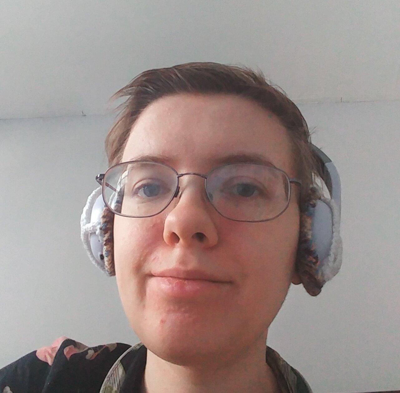 Me wearing the headphones with attached ear pads (the straps blend in fairly well with the headphones)